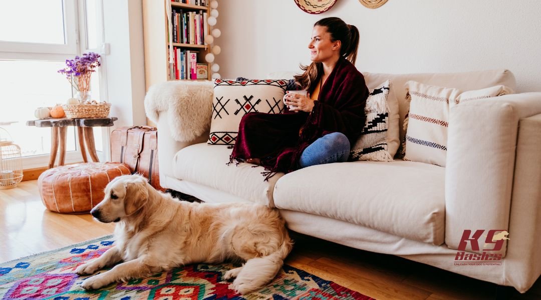 Womam on couch with dog at the foot of the couch