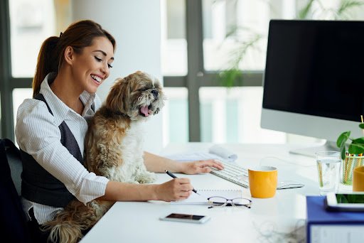 Smiling woman and emotional support dog at work
